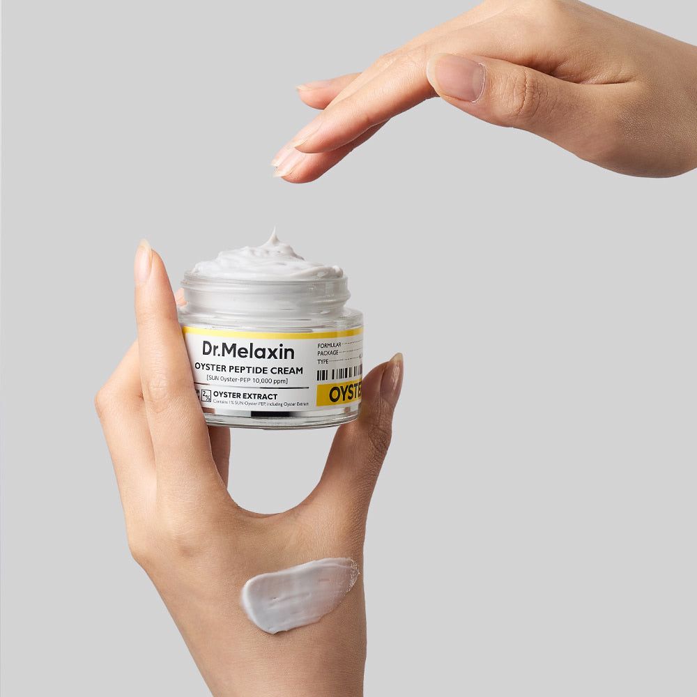 Hand die Dr. Melaxin Oyster Peptide Cream vasthoudt, met een crème-sample op de handpalm.