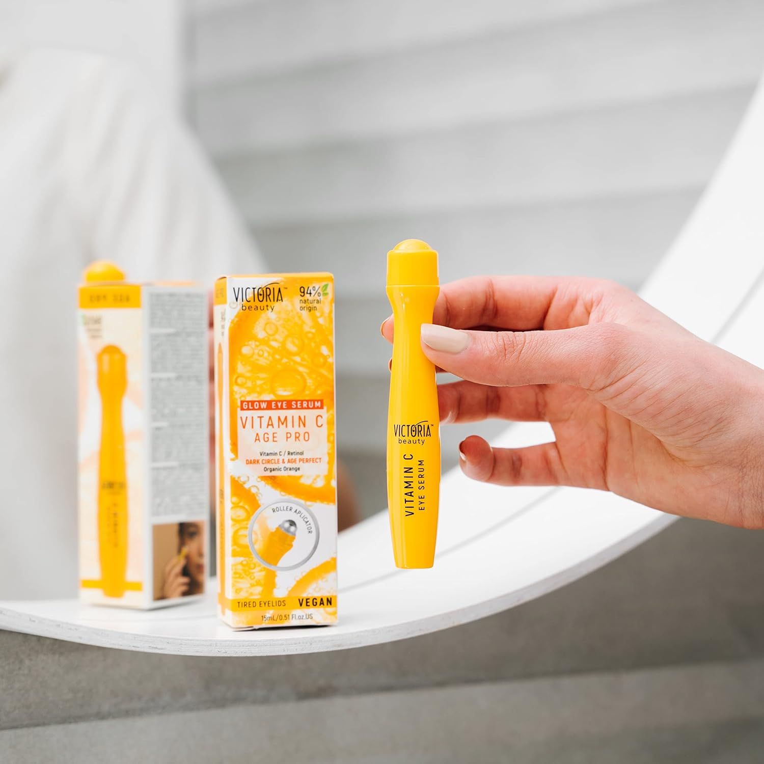 Gele oogroller in een hand. Daarnaast de verpakking. Productnaam en ingrediënten zichtbaar.