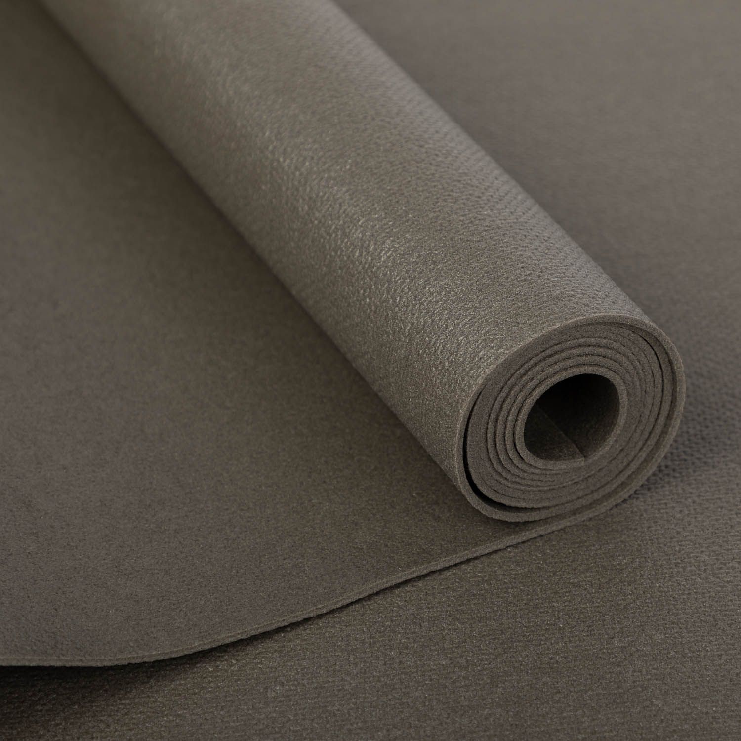 Opgerolde grijze yogamat. Close-up. Op witte achtergrond.