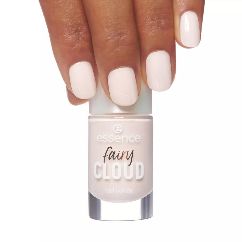 Main avec ongles vernis et flacon de vernis à ongles. Inscription "essence fairy cloud nail polish".