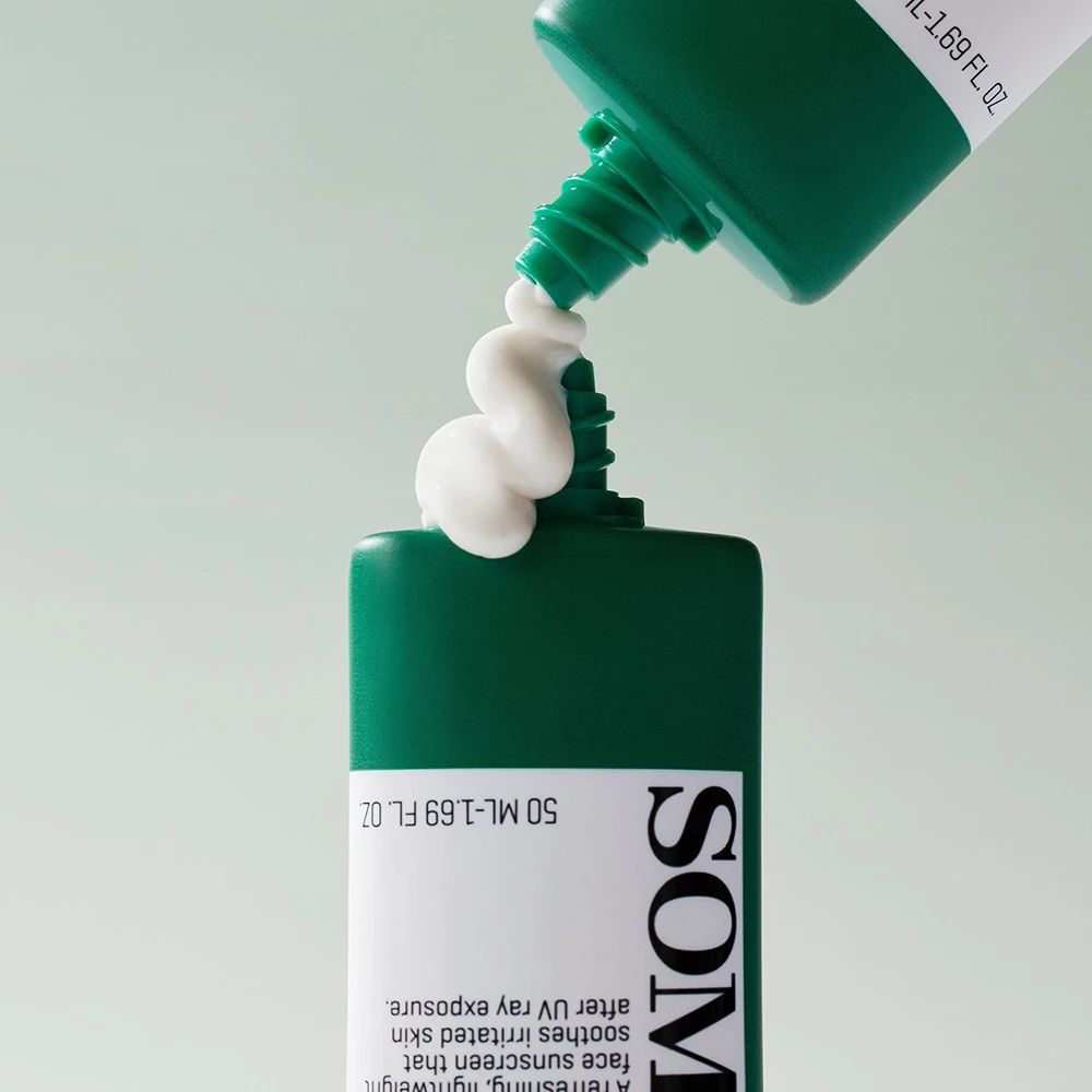 Tube verte, crème solaire sortant. Texte : SOMEBYMI. Inscription : 50 ML - 1.69 FL. OZ. La crème est blanche.