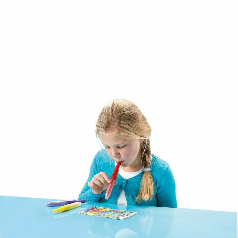 Een meisje gebruikt een rode spuitpen. Er liggen nog meer pennen en een sjabloon met kleurrijke motieven op tafel.