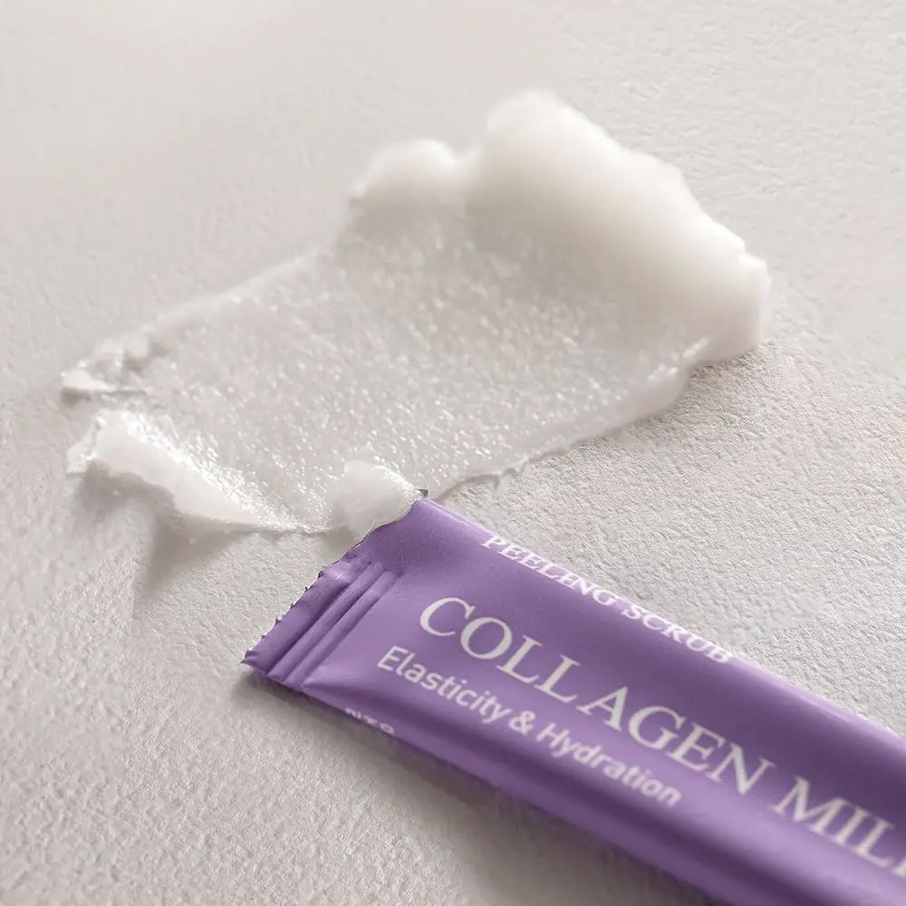 Paars zakje en product op licht oppervlak. Tekst: COLLAGEN MILKY, PEELING SCRUB. Product zichtbaar.