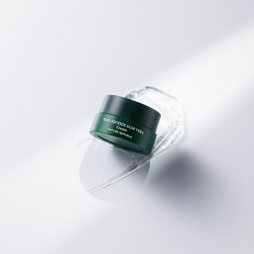 Groene crème pot met opschrift "REAL SQUEEZE ALOE VERA Cream" en "NATURE REPUBLIC" op witte achtergrond.
