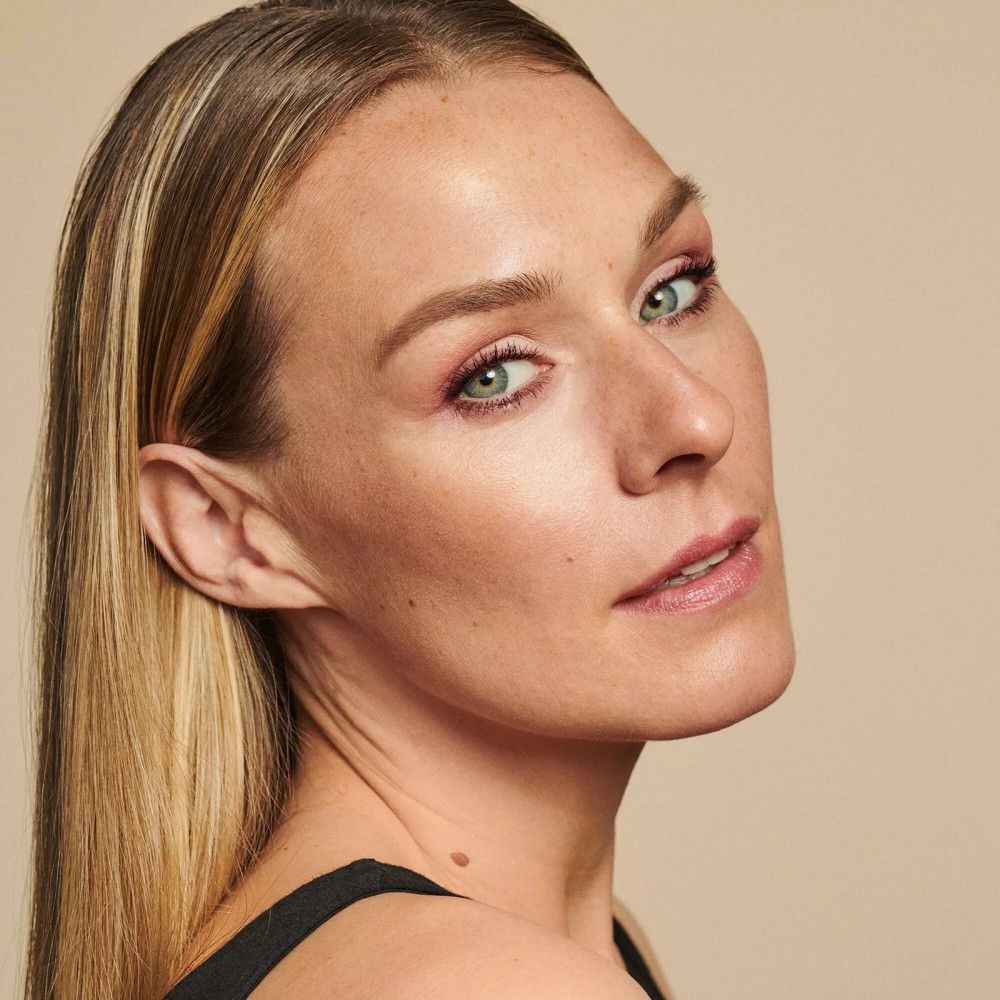 Portret van een vrouw met blond haar en groene ogen. Wenkbrauwen zijn opgemaakt met wenkbrauwpoeder.