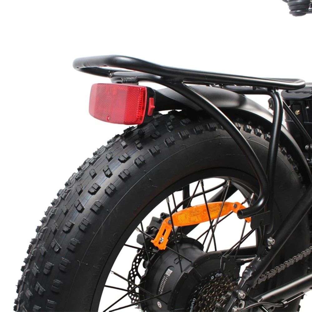 Vue arrière d'un vélo électrique. Porte-bagages noir, feu arrière rouge, pneus.