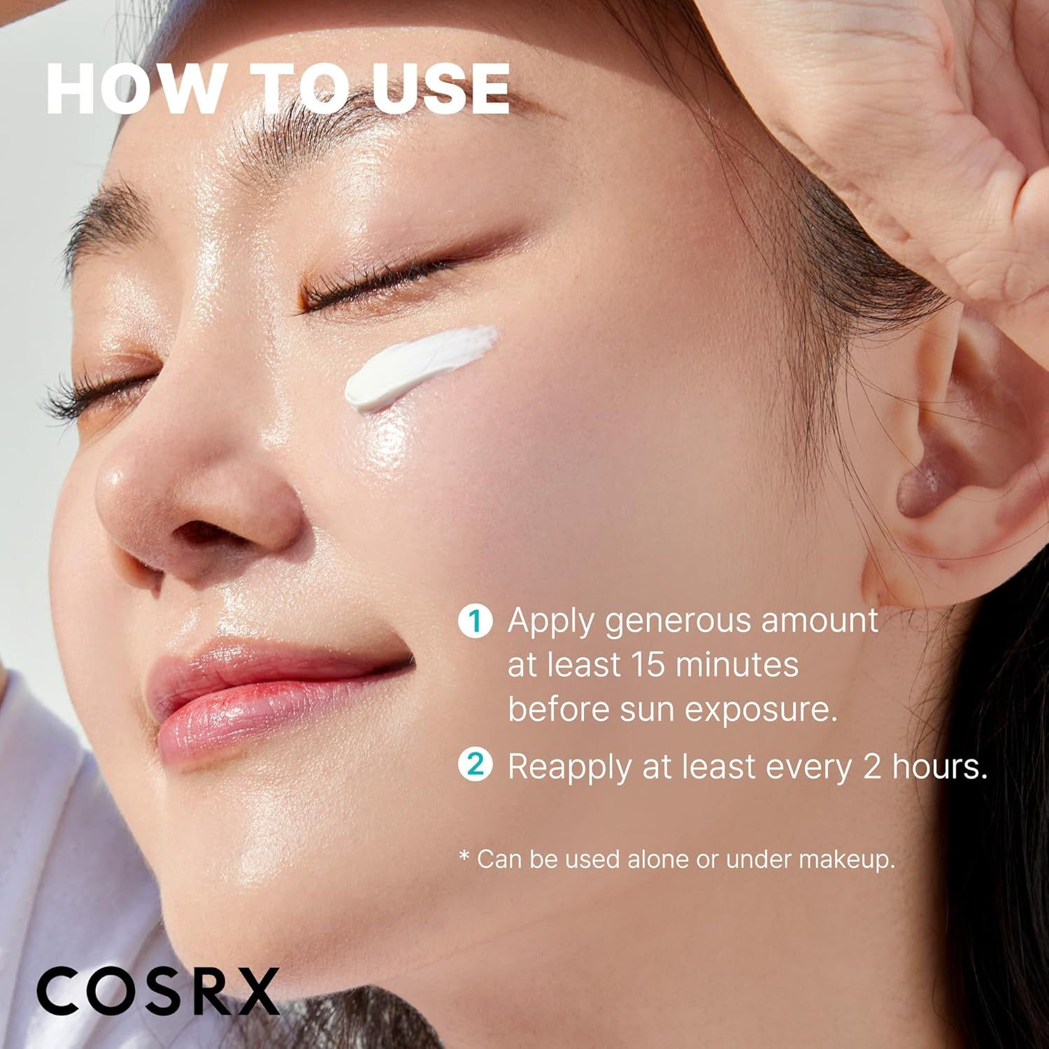 Une femme applique la crème solaire COSRX sur sa joue. Instructions : Appliquer généreusement, réappliquer toutes les 2 heures.