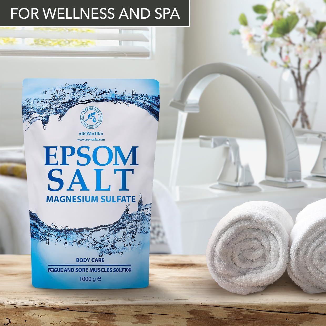Sachet de sel d'Epsom AROMATIKA à côté d'une baignoire remplie avec robinet.
