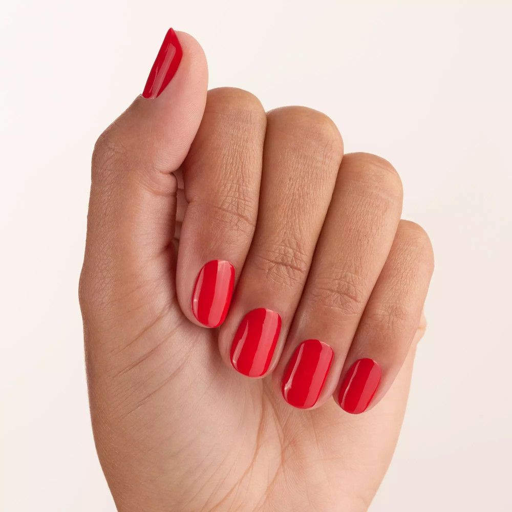 Main avec ongles vernis en rouge. Tous les doigts vernis, pouce également.