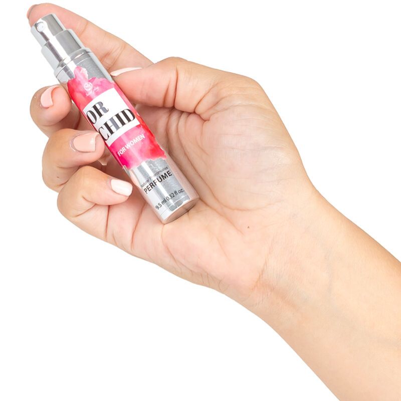 Kleine, cilindrische fles met de tekst "ORCHID FOR WOMEN", vastgehouden door een hand.