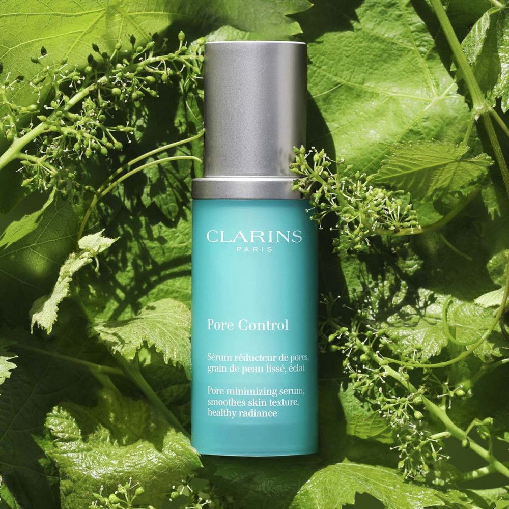 Flacon turquoise avec bouchon argenté, entouré de feuilles vertes. Inscription: Clarins, Pore Control. Texte: Serum réducteur de pores.