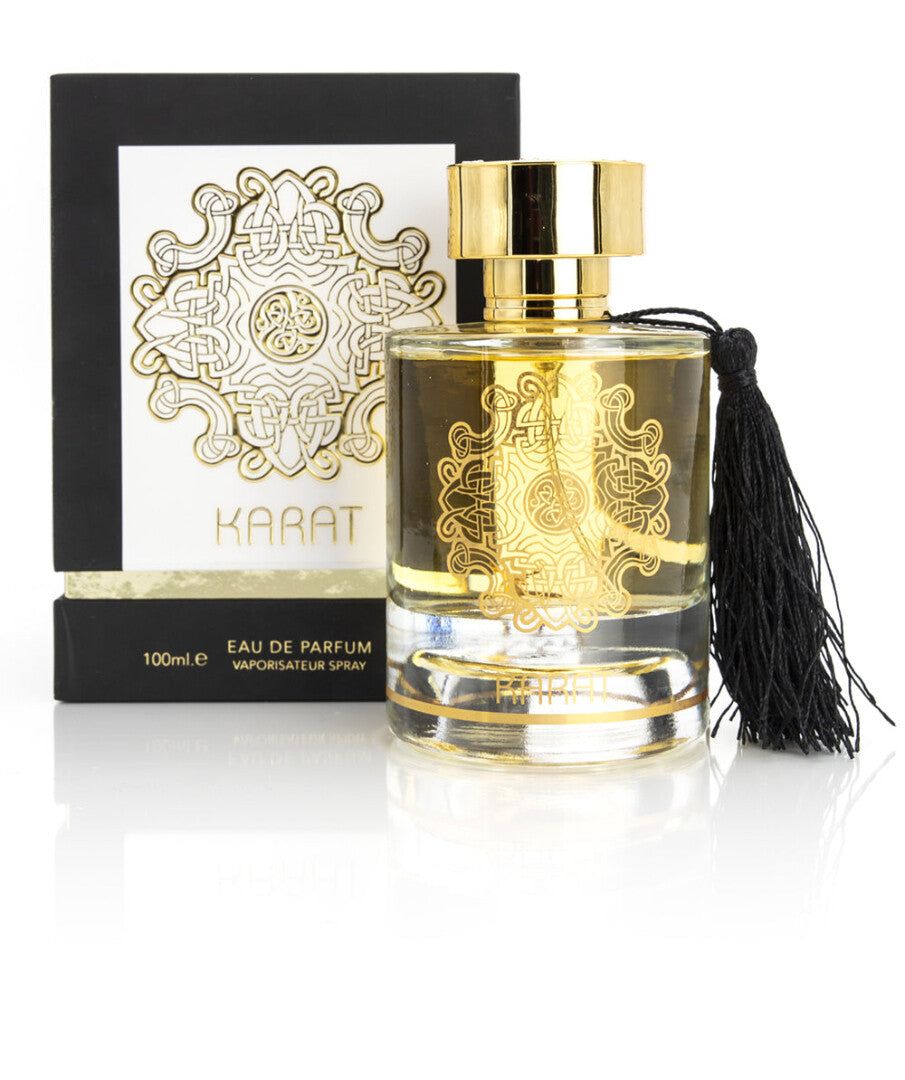 Flacon de parfum avec bouchon et ornements dorés, à côté d'une boîte bleu foncé à motif géométrique.