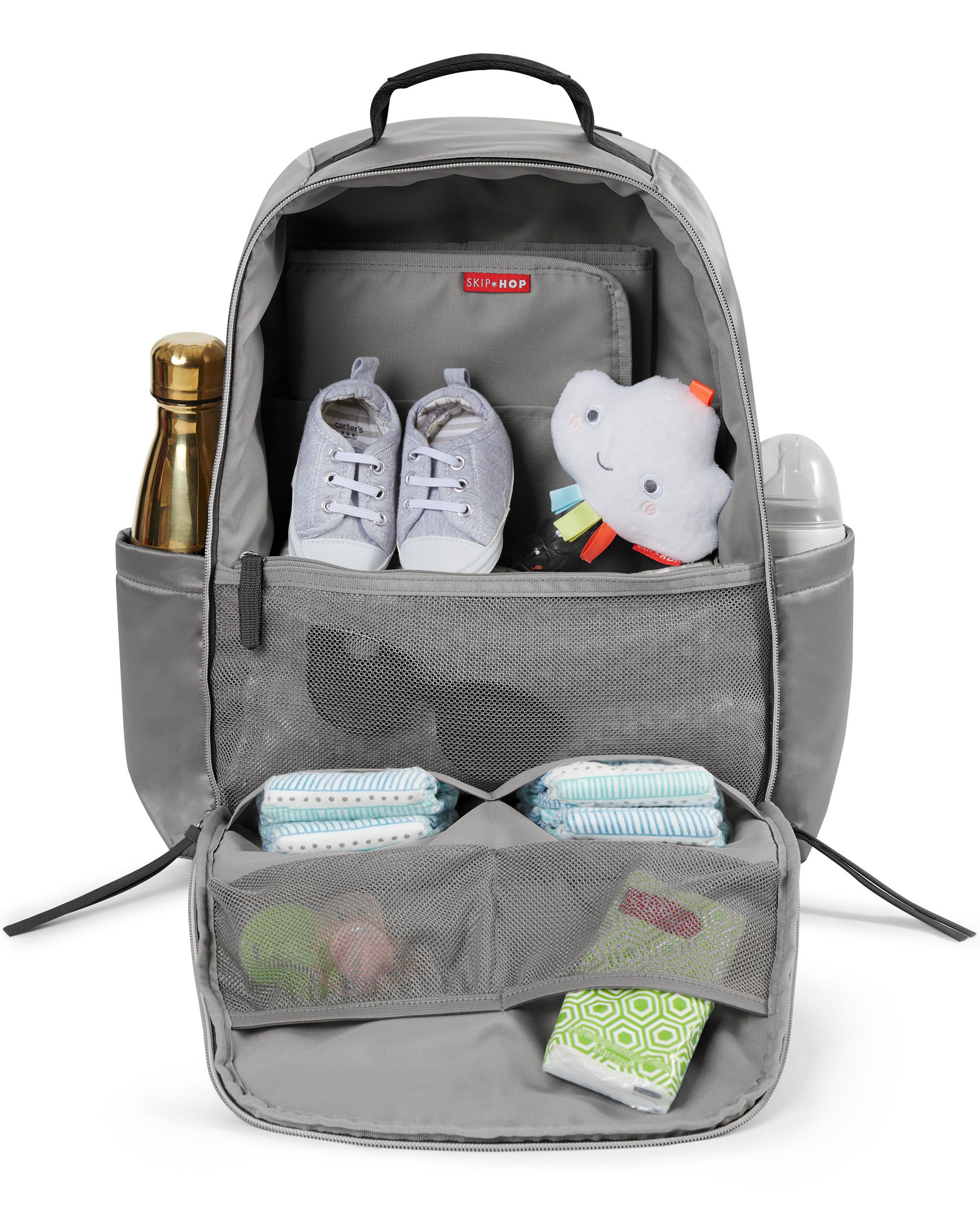Grijze luiertas, open. Fles, schoenen, speelgoed, luiers, aankleedkussen. Skip Hop-logo.