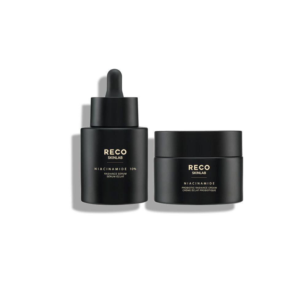 Deux flacons noirs. À gauche : flacon de sérum avec pipette. À droite : pot. Texte doré : RECO SKINLAB, Niacinamide 10%.
