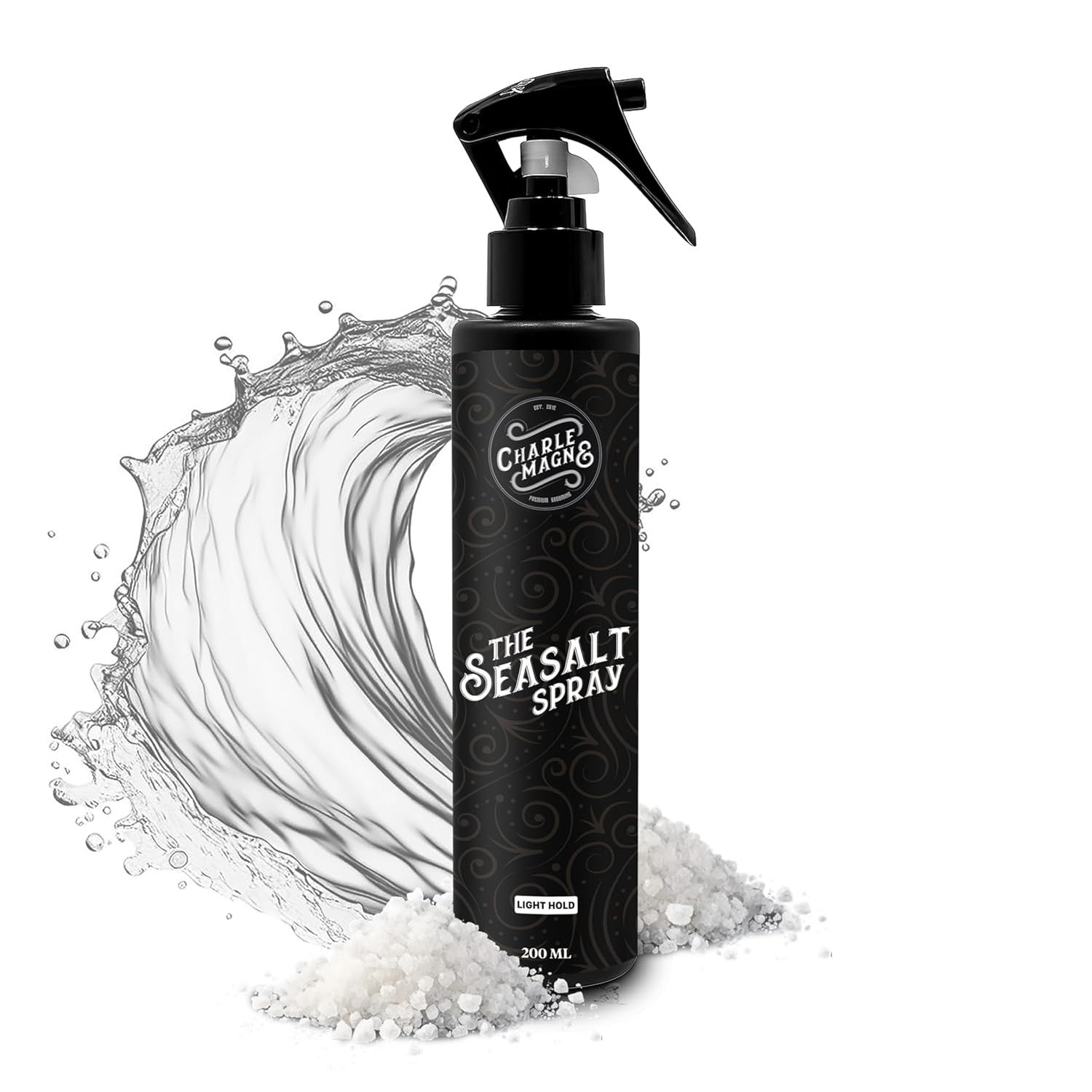 Flacon pulvérisateur noir avec l'inscription "THE SEASALT SPRAY". Eau et sel en arrière-plan. Marque : Charlemagne.