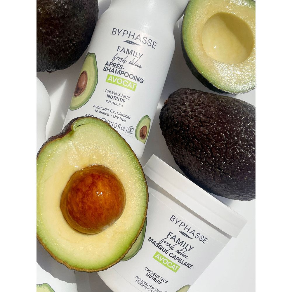 Produits capillaires Byphasse et avocat. Bouteille de shampooing et pot de masque, moitiés et avocats entiers.
