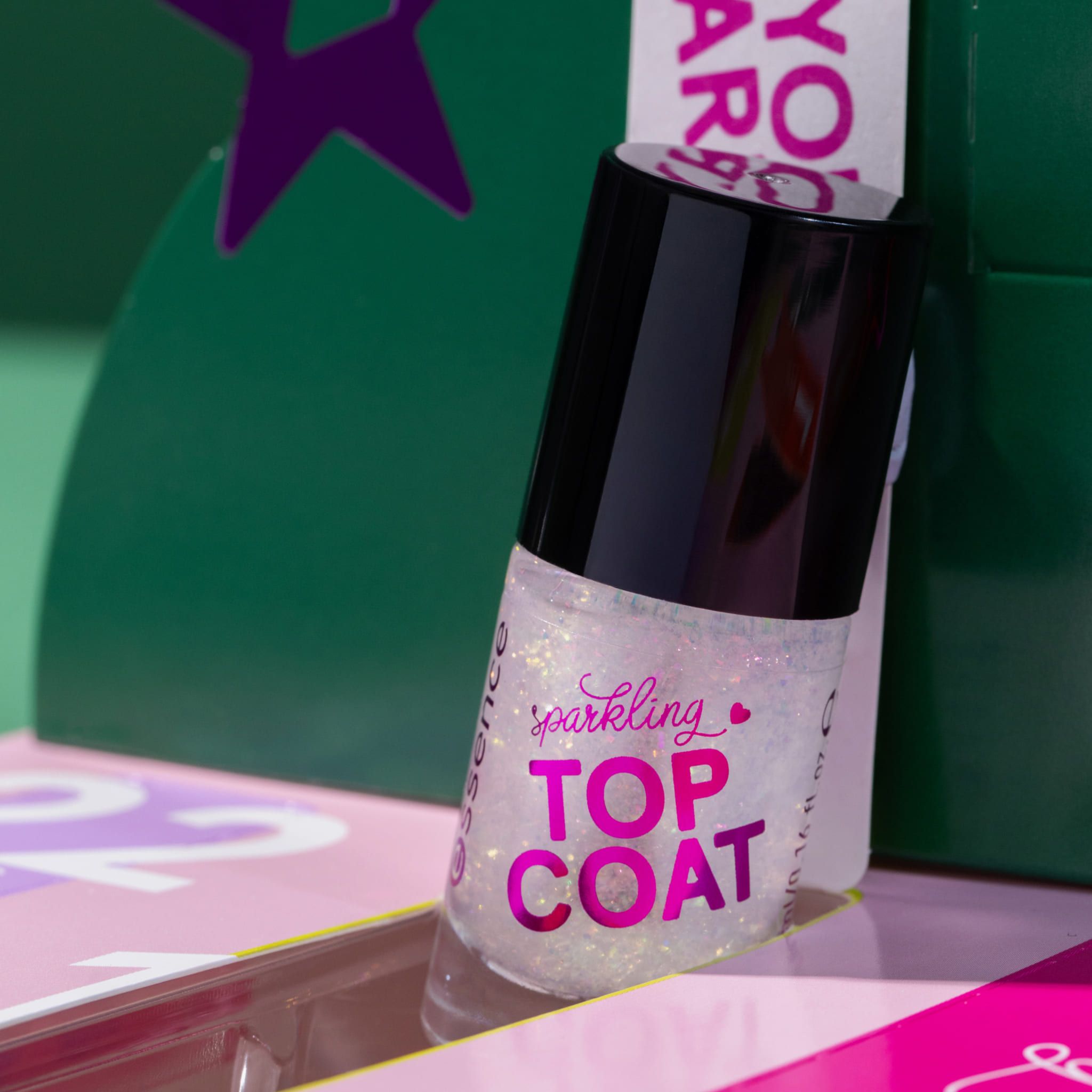 Essence Sparkling Top Coat. Transparante fles met glitter. Zwarte dop.