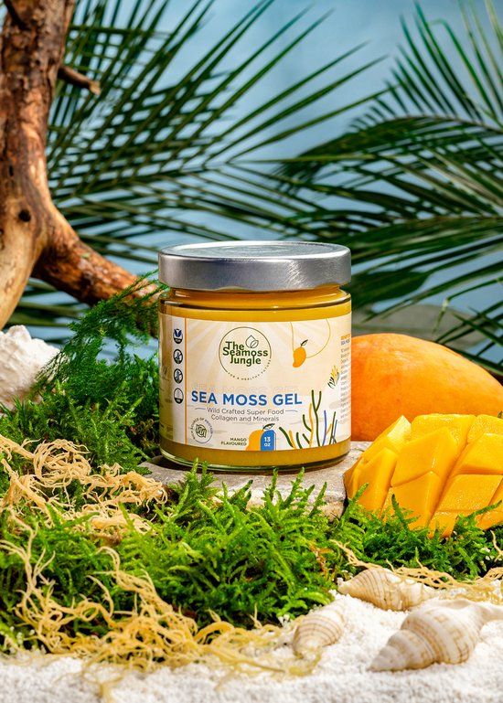 Potje geel gel, omringd door zeewier, mos en mango. Opschrift: Sea Moss Gel, Mango Flavour. Logo: The Seamoss Jungle.