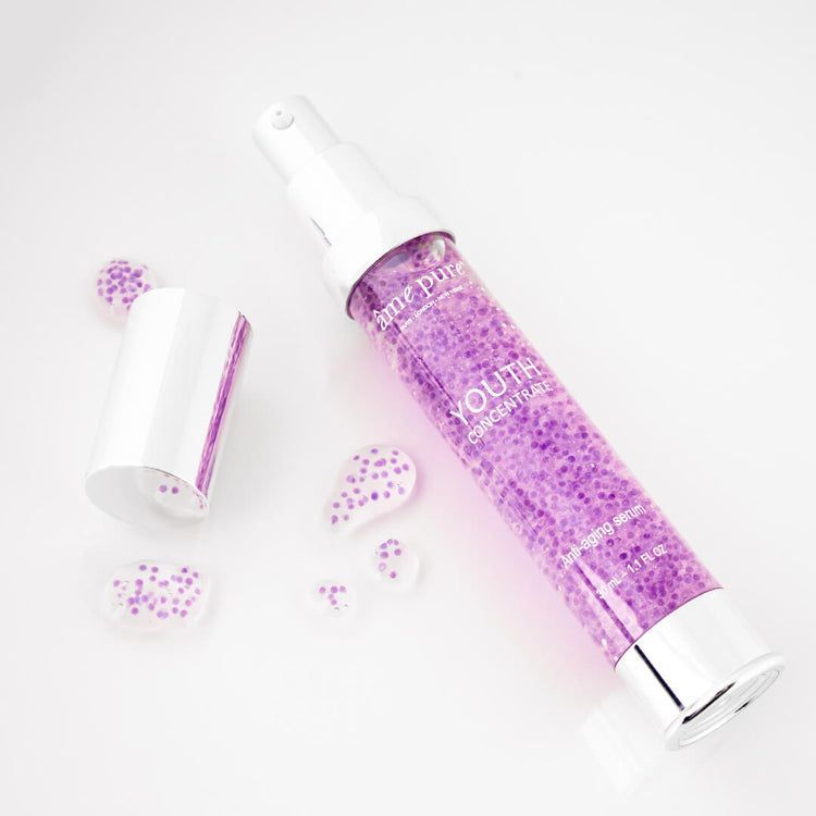 Een flacon Youth Concentrate Serum met geopende dop en serumdruppels.
