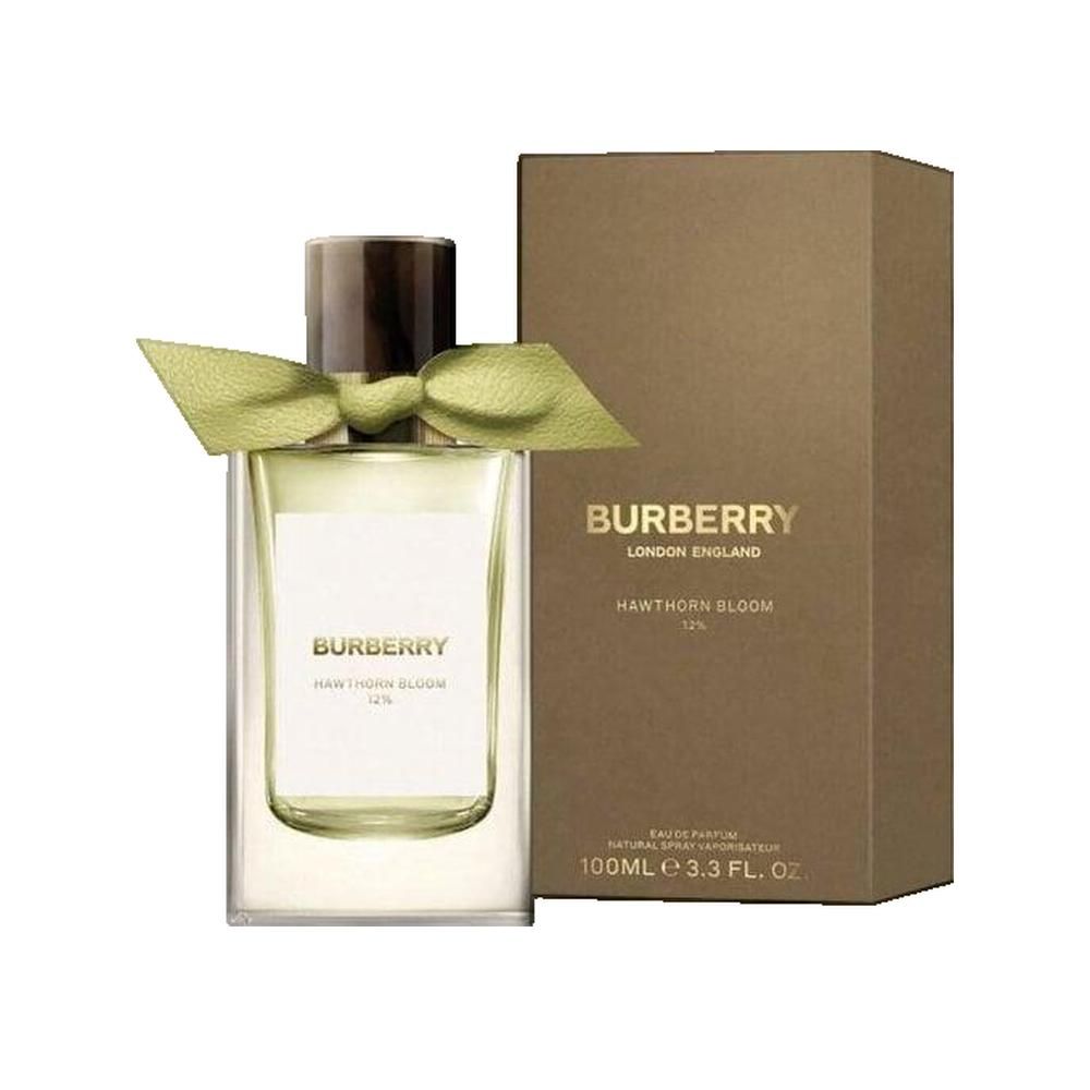 Flacon de parfum avec emballage. Flacon avec ruban jaune, rectangulaire. Emballage marron avec texte.