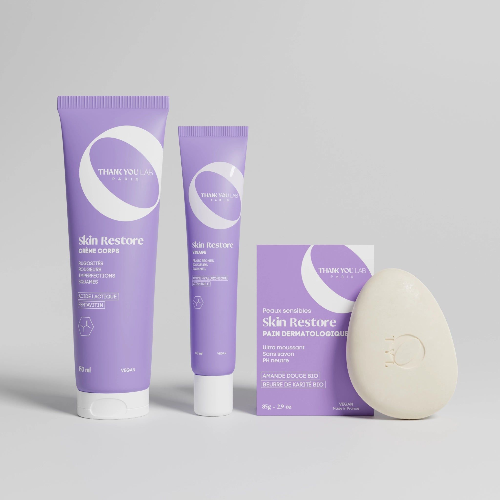 Trois tubes violets et un pain de savon ovale. Les produits indiquent "Skin Restore".
