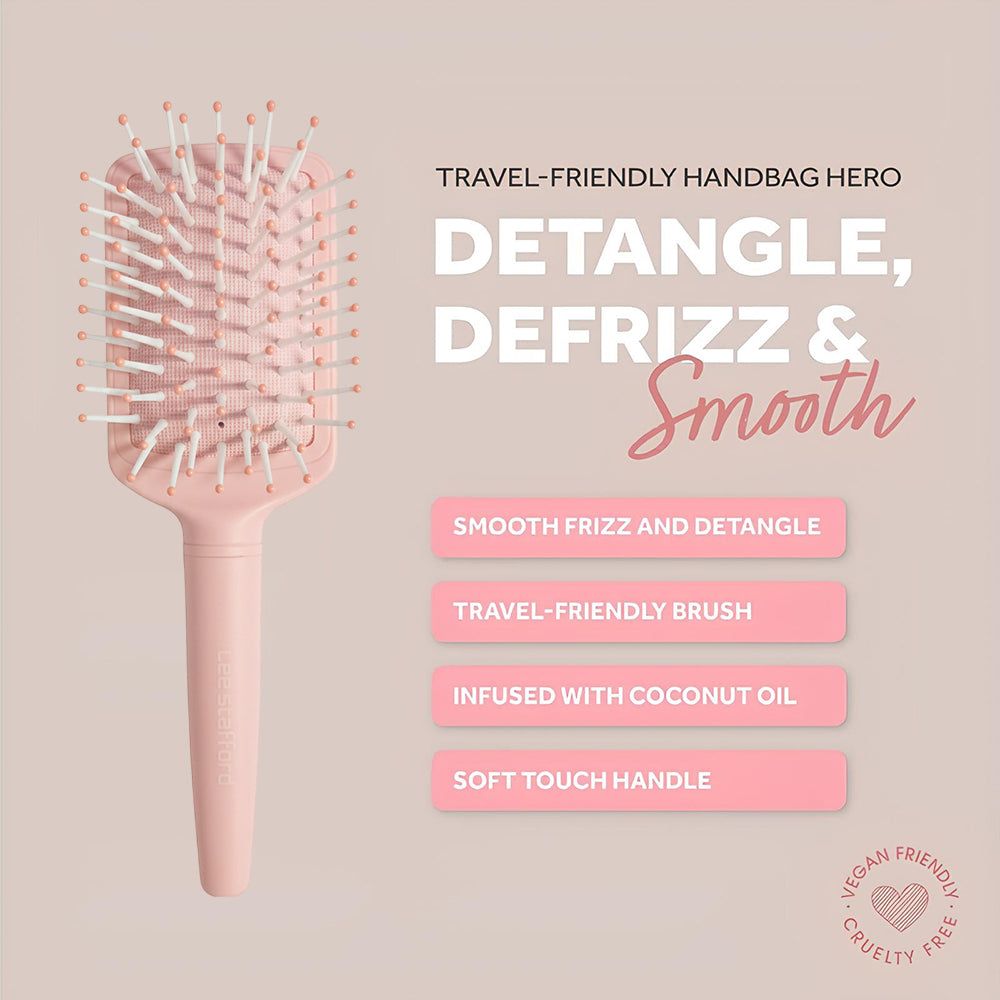 Une brosse à cheveux rose pâle avec des picots blanc-rose et du texte sur fond clair.