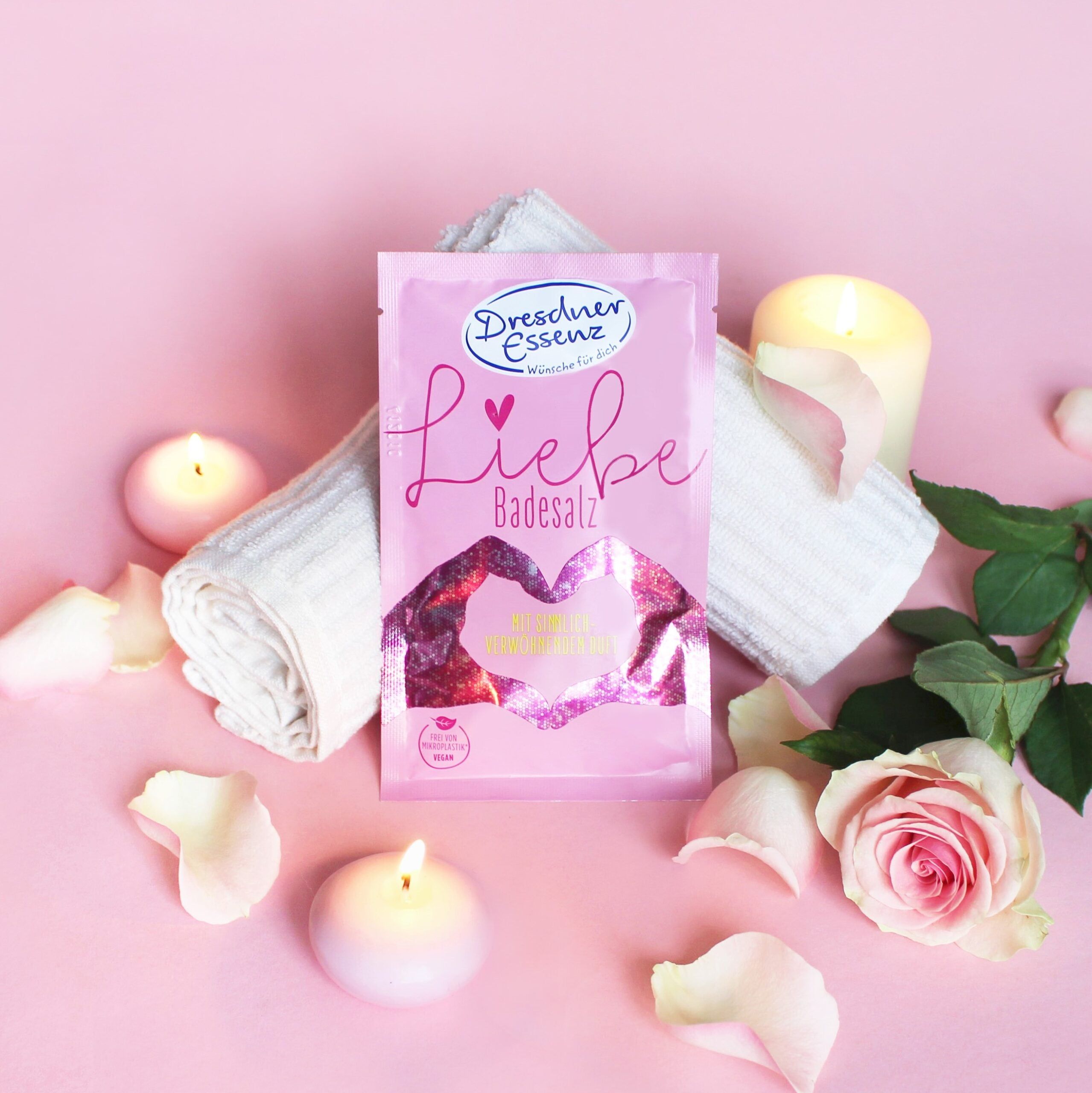 Sachet de sel de bain rose 'Liebe' et 'Dresdner Essenz', entouré de pétales de rose et de bougies.