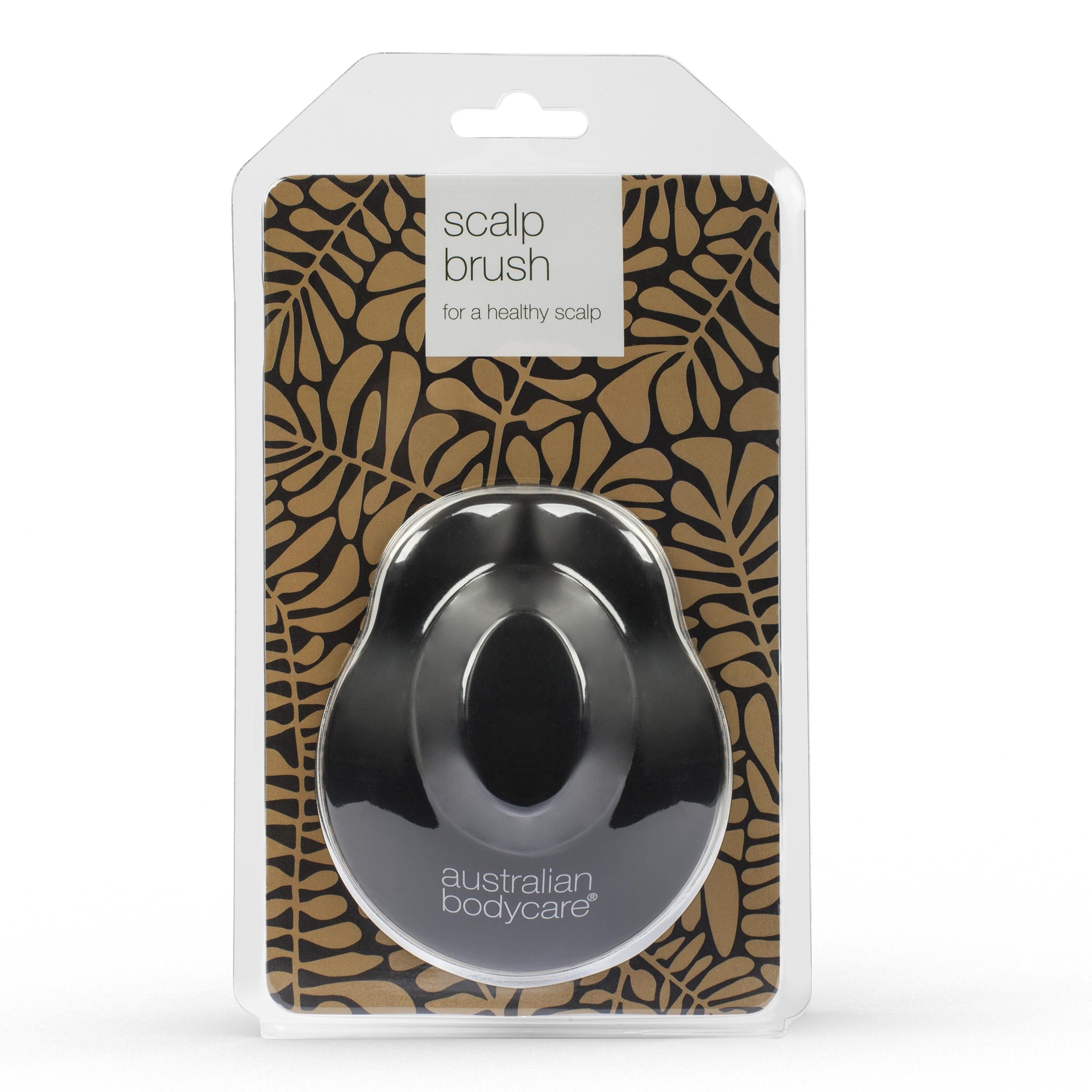 Zwarte hoofdhuidmassageborstel in blisterverpakking. Opschrift: « scalp brush for a healthy scalp » en « australian bodycare ».