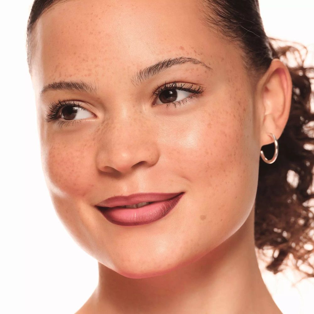 Vrouw met lippenstift. Donkerbruine lippen. Huid met sproeten.