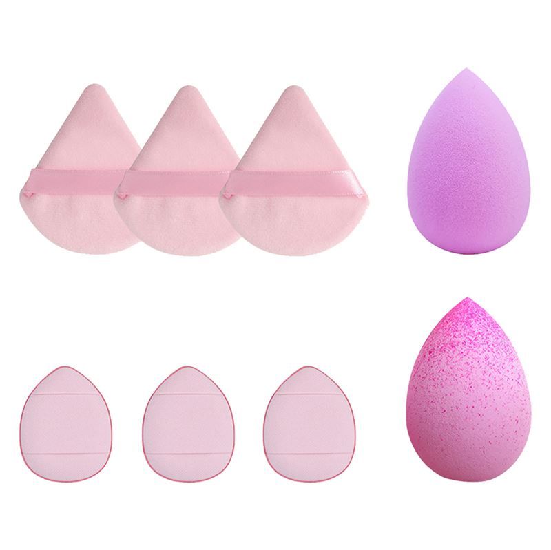 Éponges de maquillage de différentes formes. Éponges triangulaires avec des rubans et éponges en forme de goutte. Plusieurs éponges sont visibles.