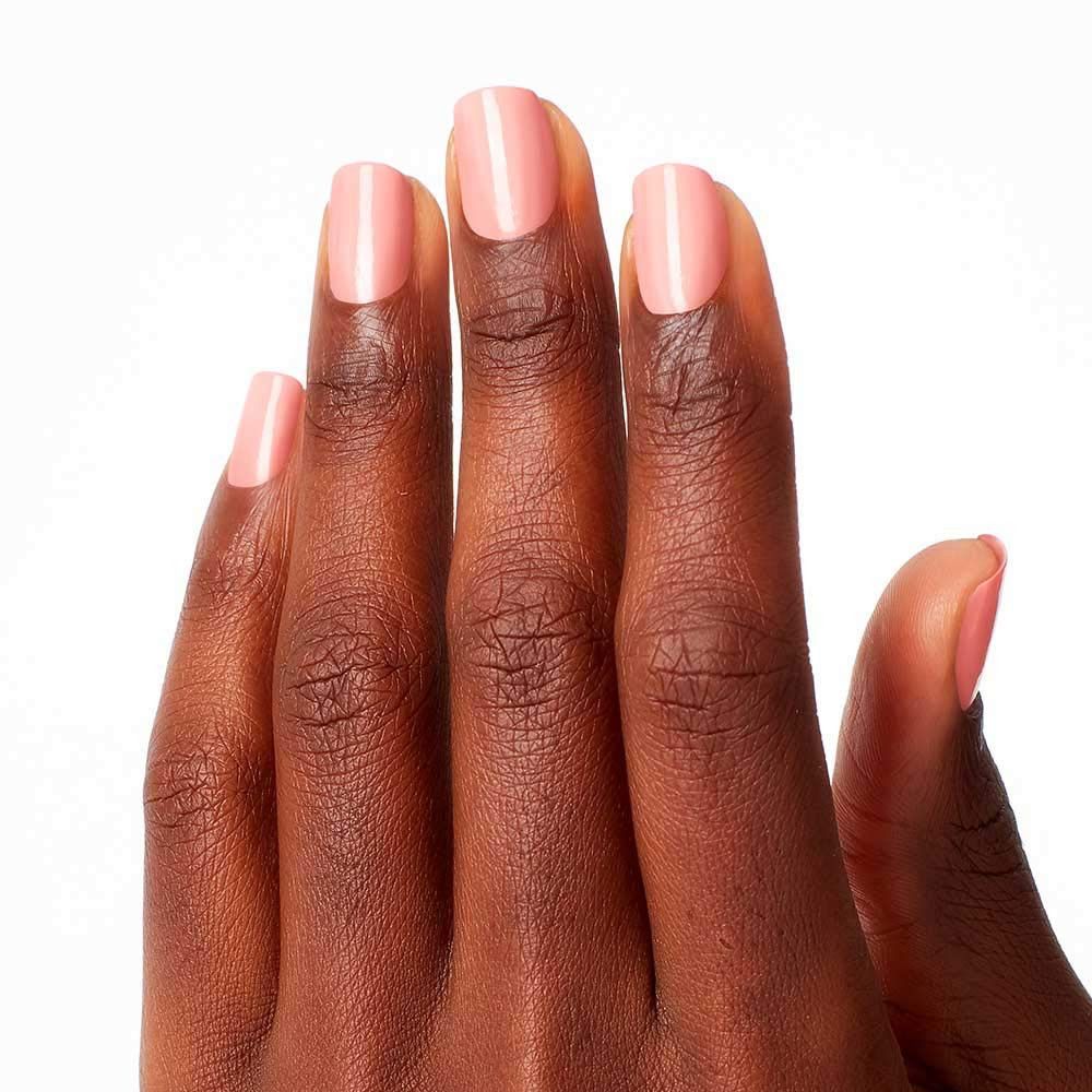 Hand met gelakte nagels. De nagels zijn gelakt met roze nagellak.