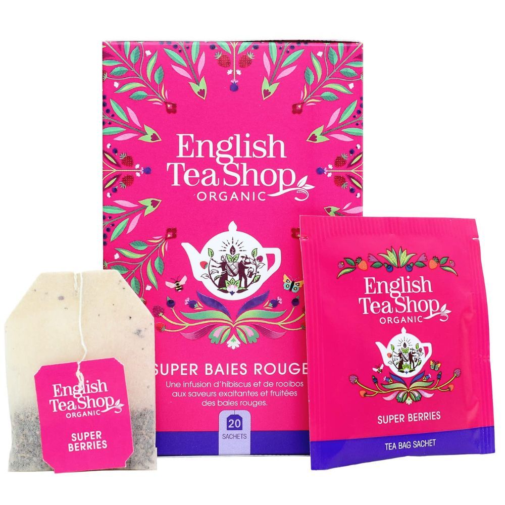 Boîte rose avec sachets de thé. Inscription: English Tea Shop Organic, Super Baies Rouges. Sachet de thé et sachet individuel.