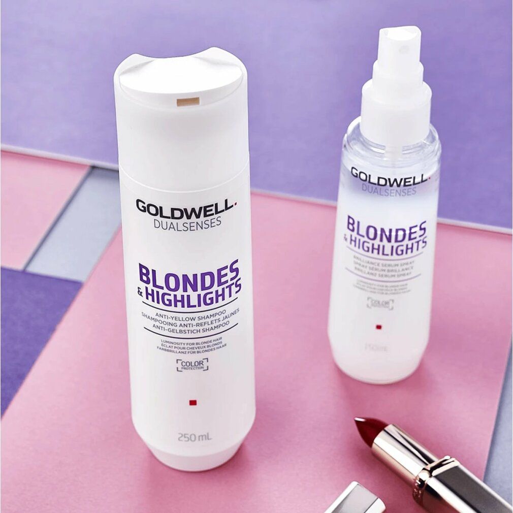 Deux flacons blancs Goldwell Blondes & Highlights Shampoo. Un avec vaporisateur. Sur fond rose et violet. Rouge à lèvres.