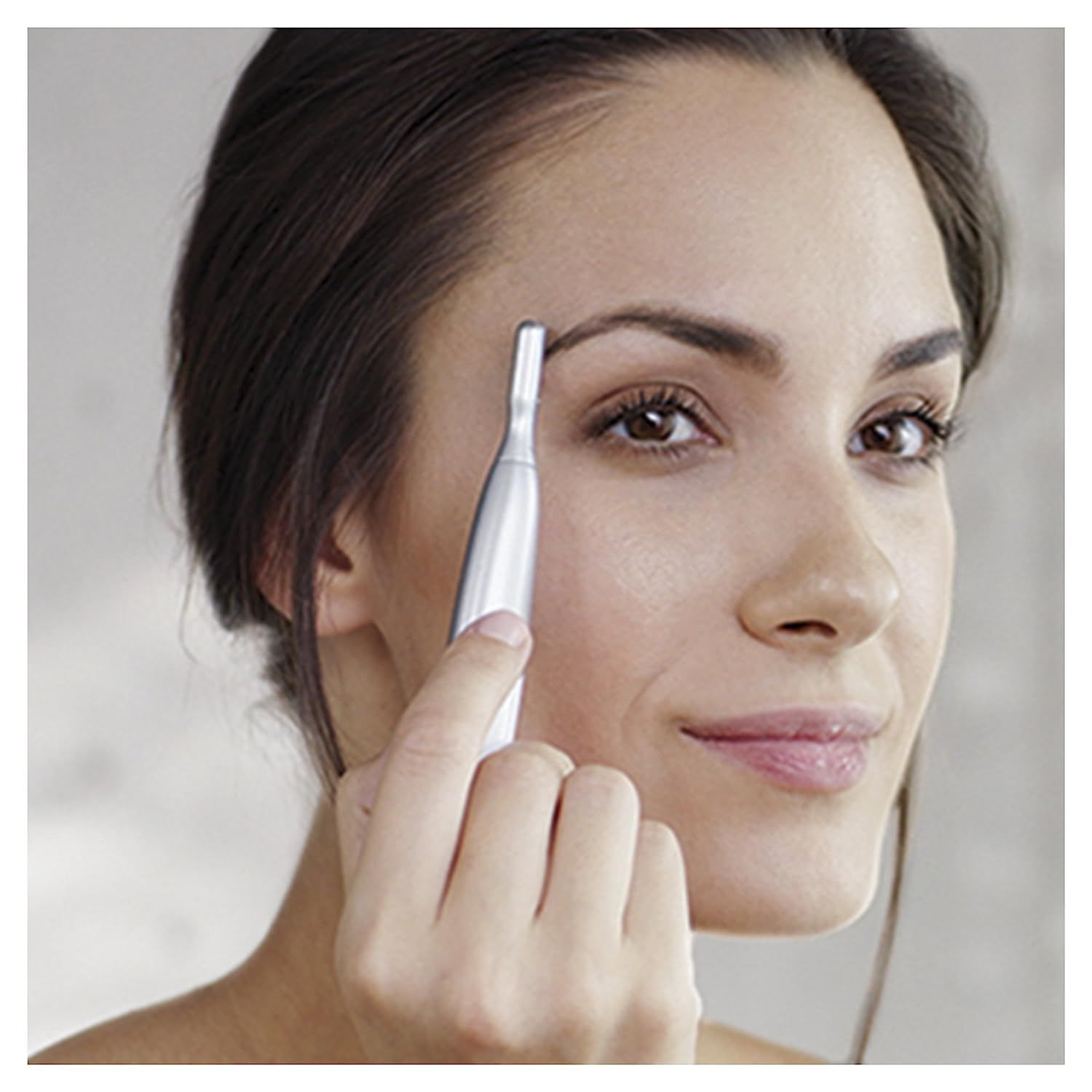 Vrouw trimt wenkbrauwen met de Braun Silk-épil trimmer. Close-up.