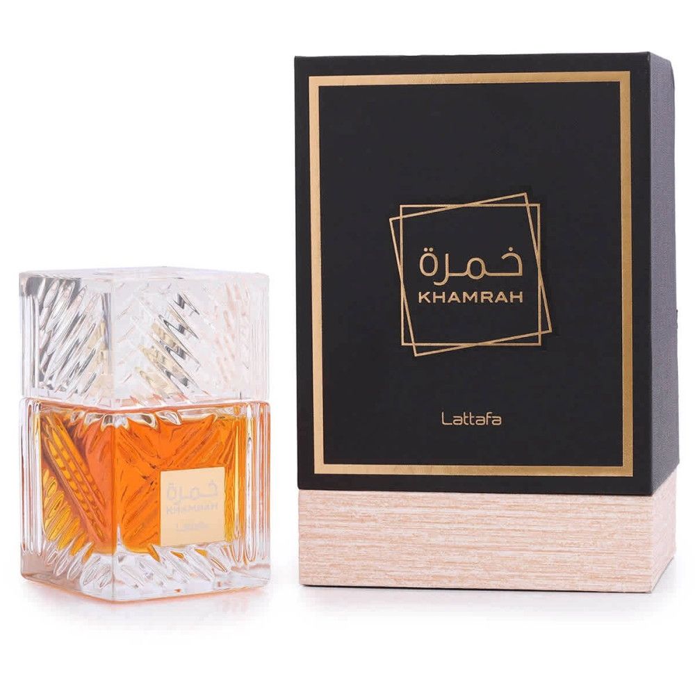 Flacon de parfum et emballage. Flacon carré transparent, liquide doré. Boîte noire avec détails dorés et inscription.