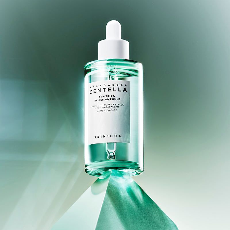 Flacon en verre vert avec bouchon et pipette blancs. Étiquette avec nom et informations. SKIN1004.