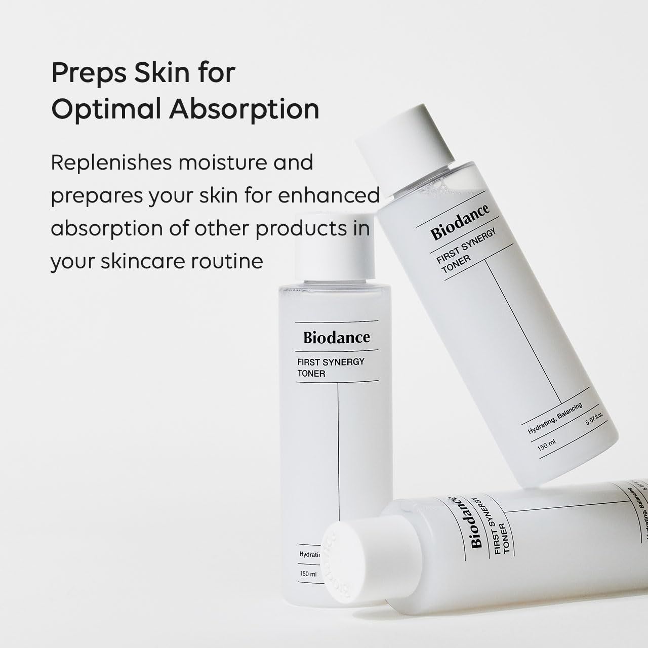 Trois flacons blancs avec bouchons blancs. Inscription : Biodance First Synergy Toner. Texte : Preps Skin for Optimal Absorption.