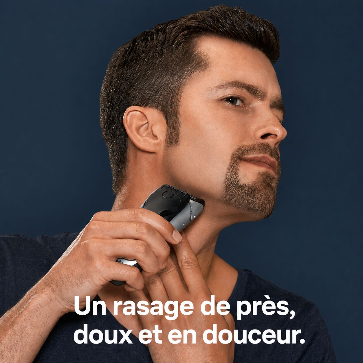 Homme se rasant le cou avec un rasoir électrique. L'appareil est noir et argenté.