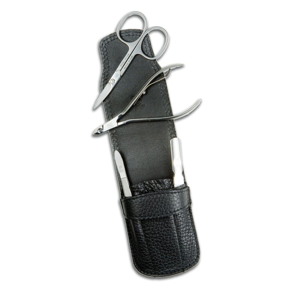 Manicureset in zwarte leren etui. Bevat nagelschaar, nageltang en twee andere metalen tools.