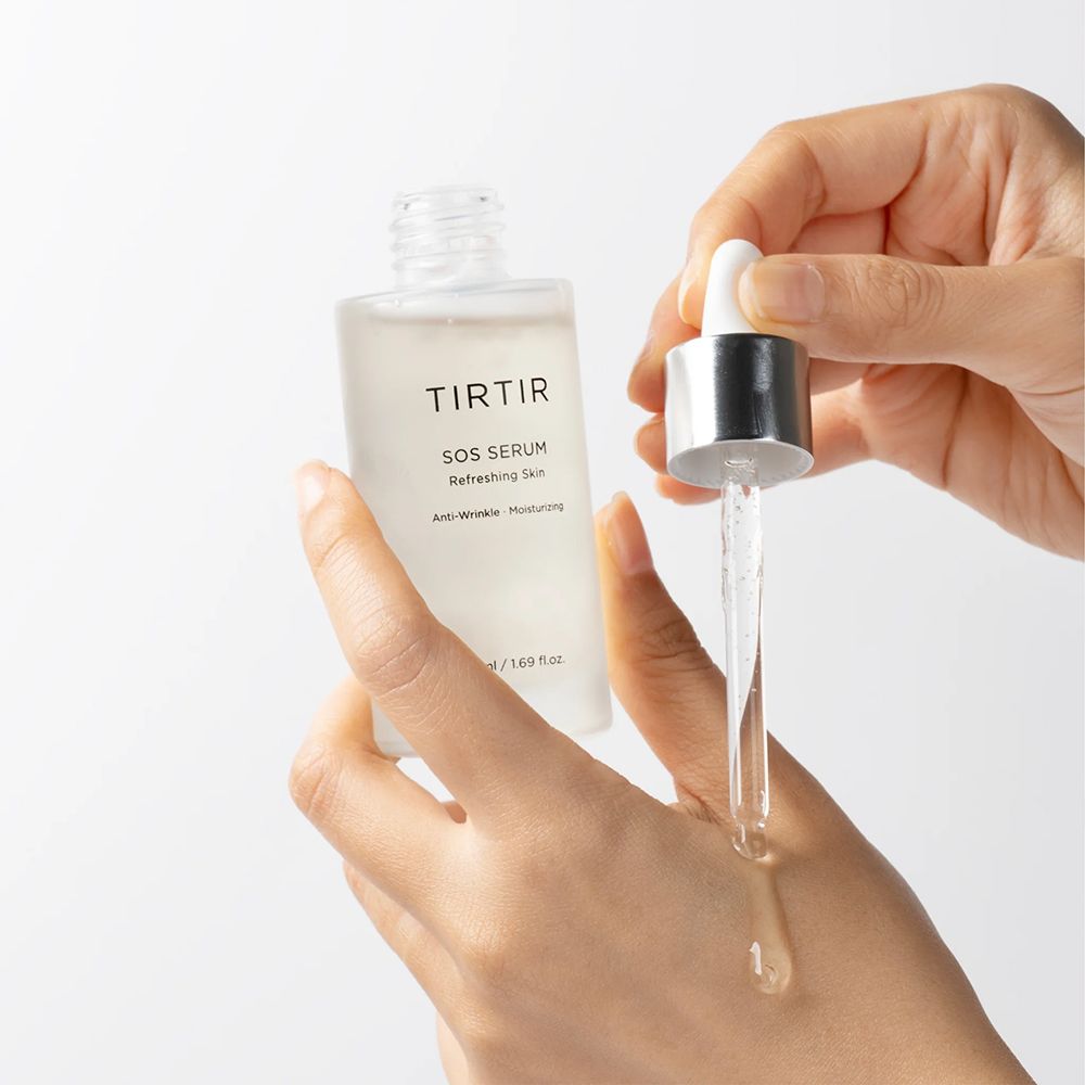 Mains appliquant le TIRTIR SOS Serum du compte-gouttes sur le dos de la main. 50ml / 1.69 fl.oz.