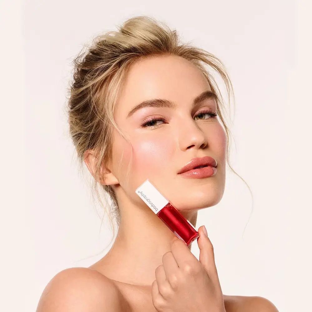 Vrouw houdt lipglossflesje vast. Bodyography staat op de dop.
