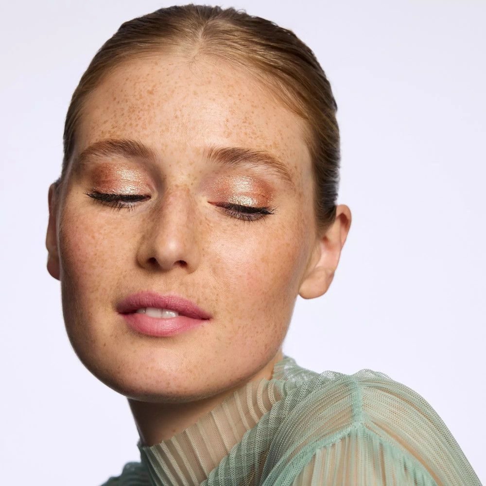 Portrait d'une femme aux yeux fermés. De l'ombre à paupières est appliquée sur les paupières.