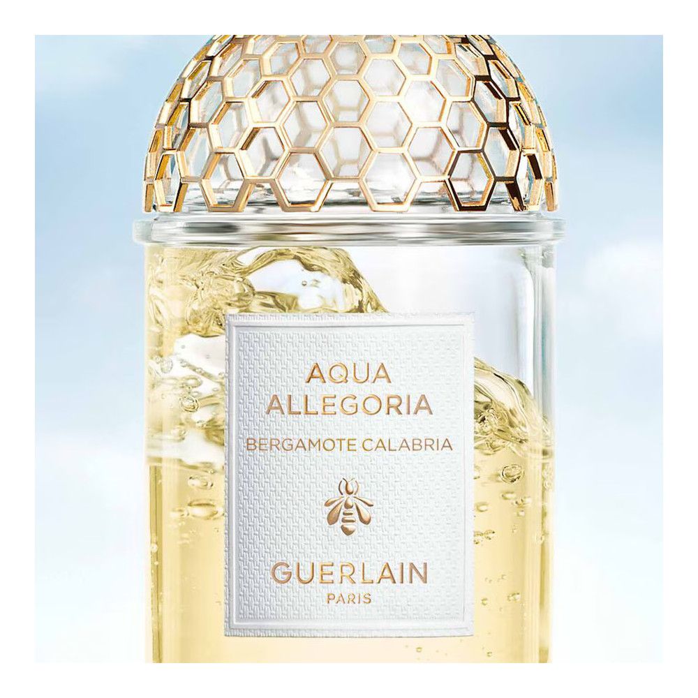 Glazen fles met gouden honingraatpatroon. Wit etiket met tekst: Aqua Allegoria Bergamote Calabria, bij, Guerlain.