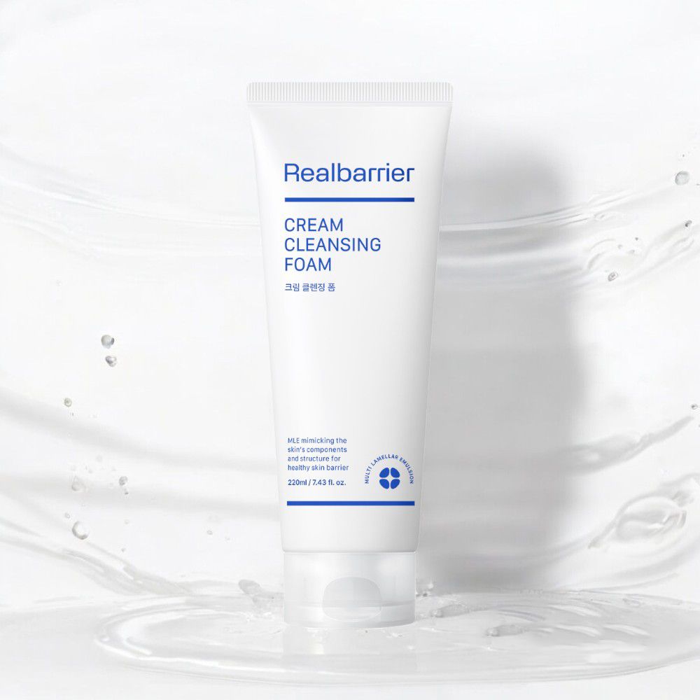 Witte tube "Realbarrier CREAM CLEANSING FOAM" tegen waterachtergrond. Bevat Koreaanse karakters en informatie over ingrediënten.
