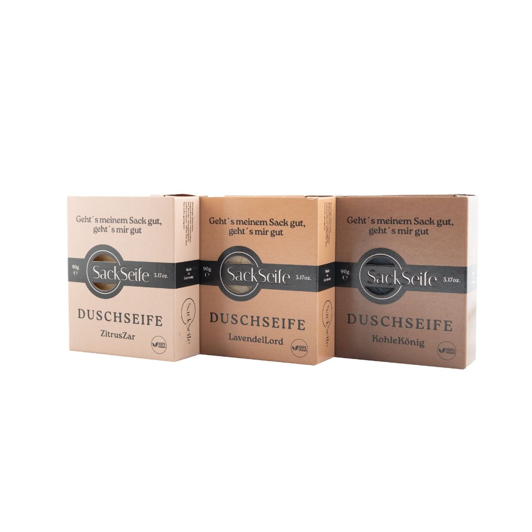 Trois boîtes de savon douche. Inscriptions : SackSeife, DUSCHSEIFE, ZitrZar, LavendelLord, KohleKönig. Emballage en carton brun.