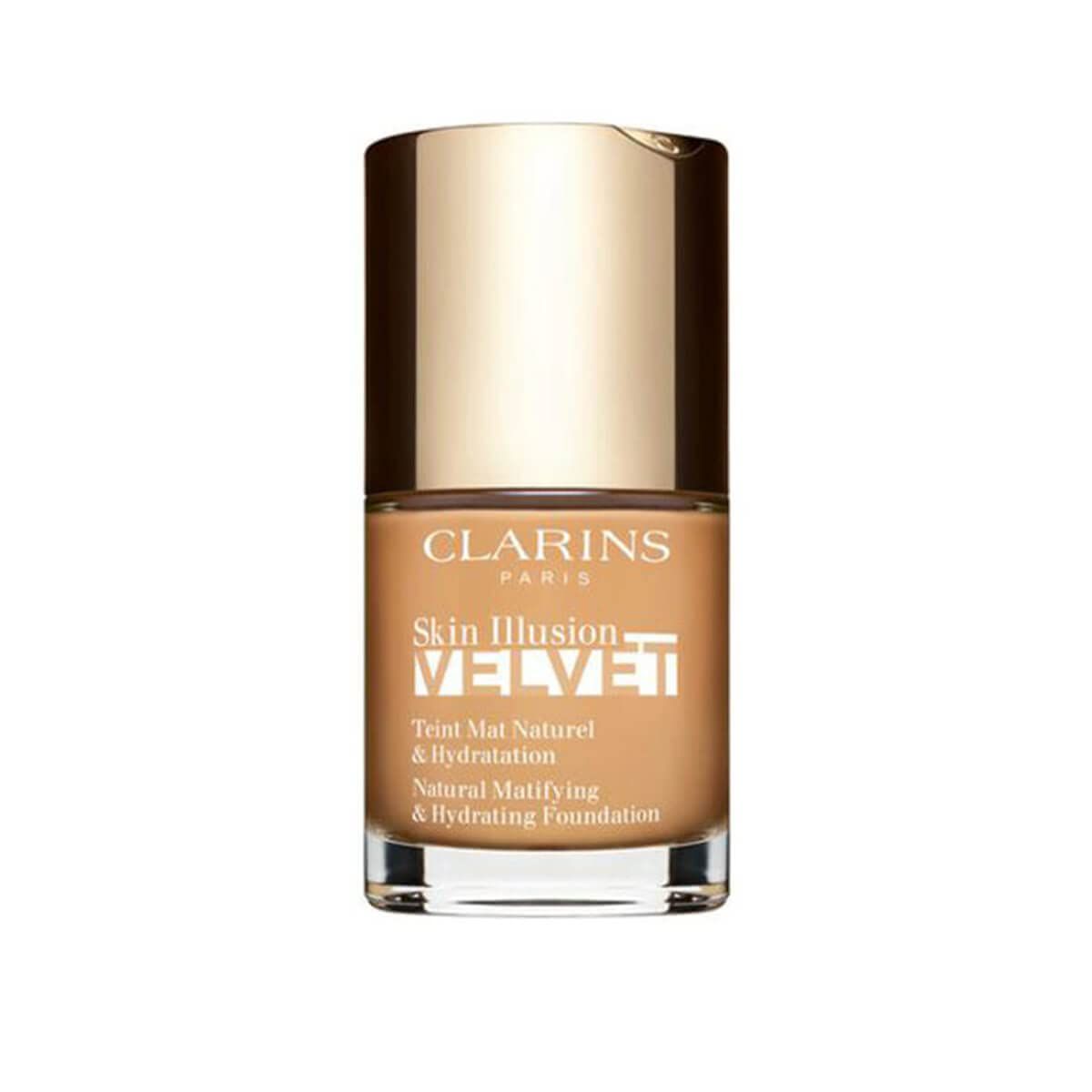 Fond de teint liquide en flacon de verre avec bouchon doré. Inscriptions: CLARINS, Skin Illusion Velvet, Teint Mat Naturel & Hydratation.