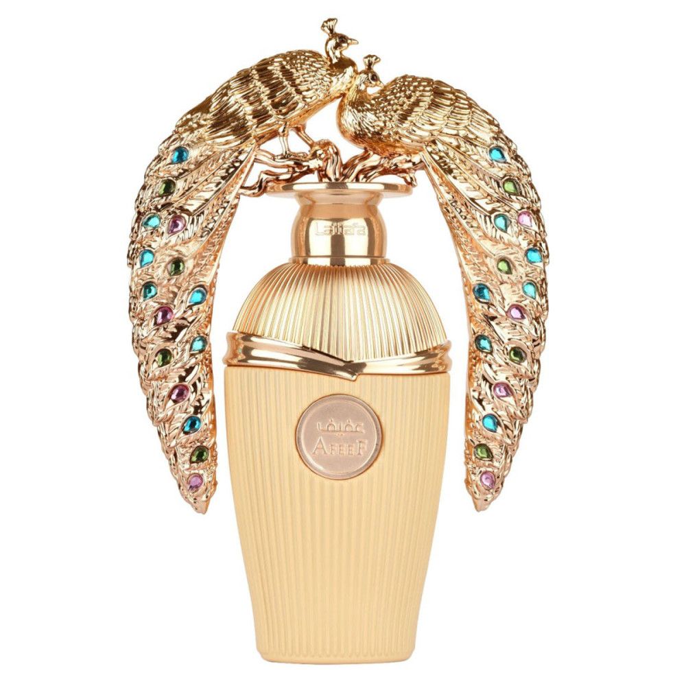 Flacon de parfum doré orné de paons dorés et de pierres précieuses colorées. Flacon à surface cannelée et étiquette ronde.