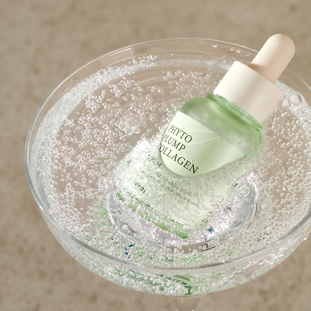 Serumfles in een glas met bubbels. Productnaam zichtbaar.