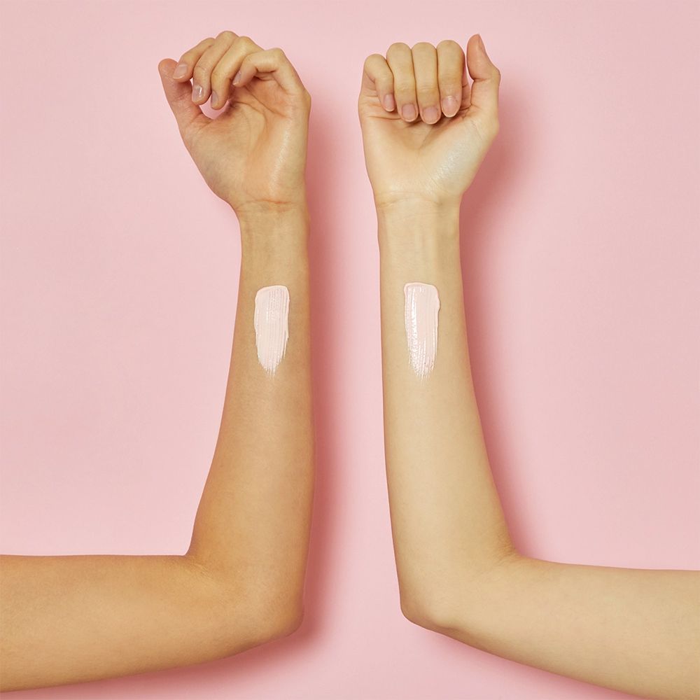 Deux avant-bras avec de la crème solaire appliquée. L'avant-bras gauche a un échantillon plus clair.