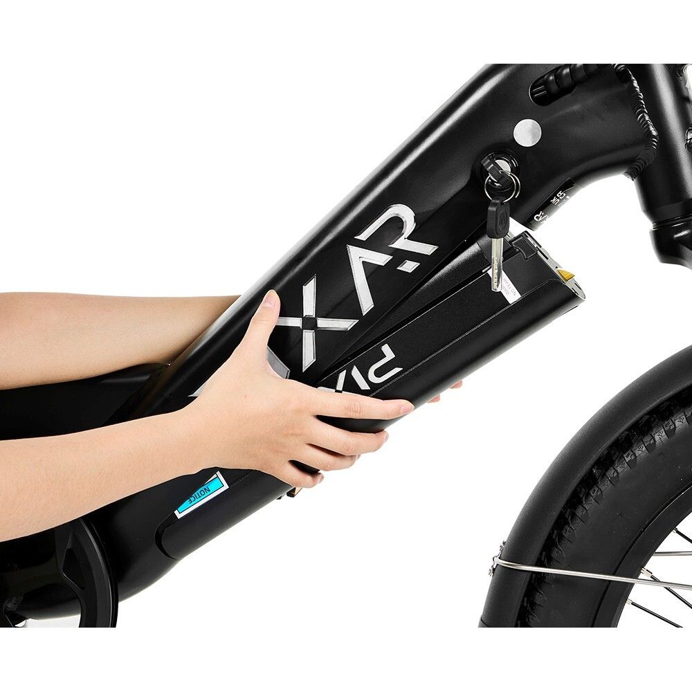 Person tenant la batterie hors du cadre du vélo. Batterie noire avec lettrage blanc. Clé dans la batterie. Cadre de vélo noir.